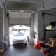 Naine jätab Tesla Model X ülesse avaneva ukse lahti ja sõidab garaaži